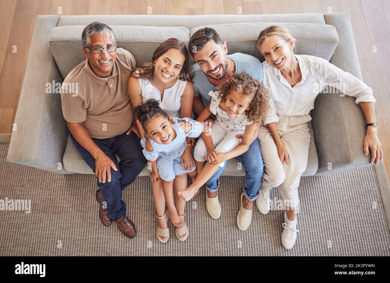 Liebe, Lächeln und Vielfalt Porträt einer glücklichen Familie Entspannen Sie sich auf dem Sofa im Wohnzimmer und verbinden Sie sich während des jährlichen Familientreffens oben. Großeltern Stockfoto