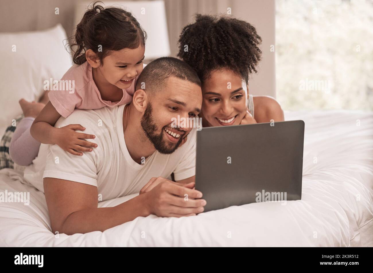 Internet, Laptop und entspannen Sie sich nach dem Aufwachen mit der Familie im Schlafzimmer, um Filme zu sehen, nach dem Internet zu suchen oder einen Streaming-Service zu genießen. Technologie, digital und lächeln mit Stockfoto
