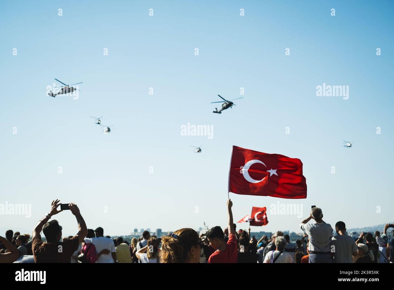 Izmir, Türkei - 9. September 2022: Nahaufnahme einer türkischen Flagge in den überfüllten Menschen mit Gendarm-Hubschraubern am Himmel am Tag der Freiheit von I Stockfoto
