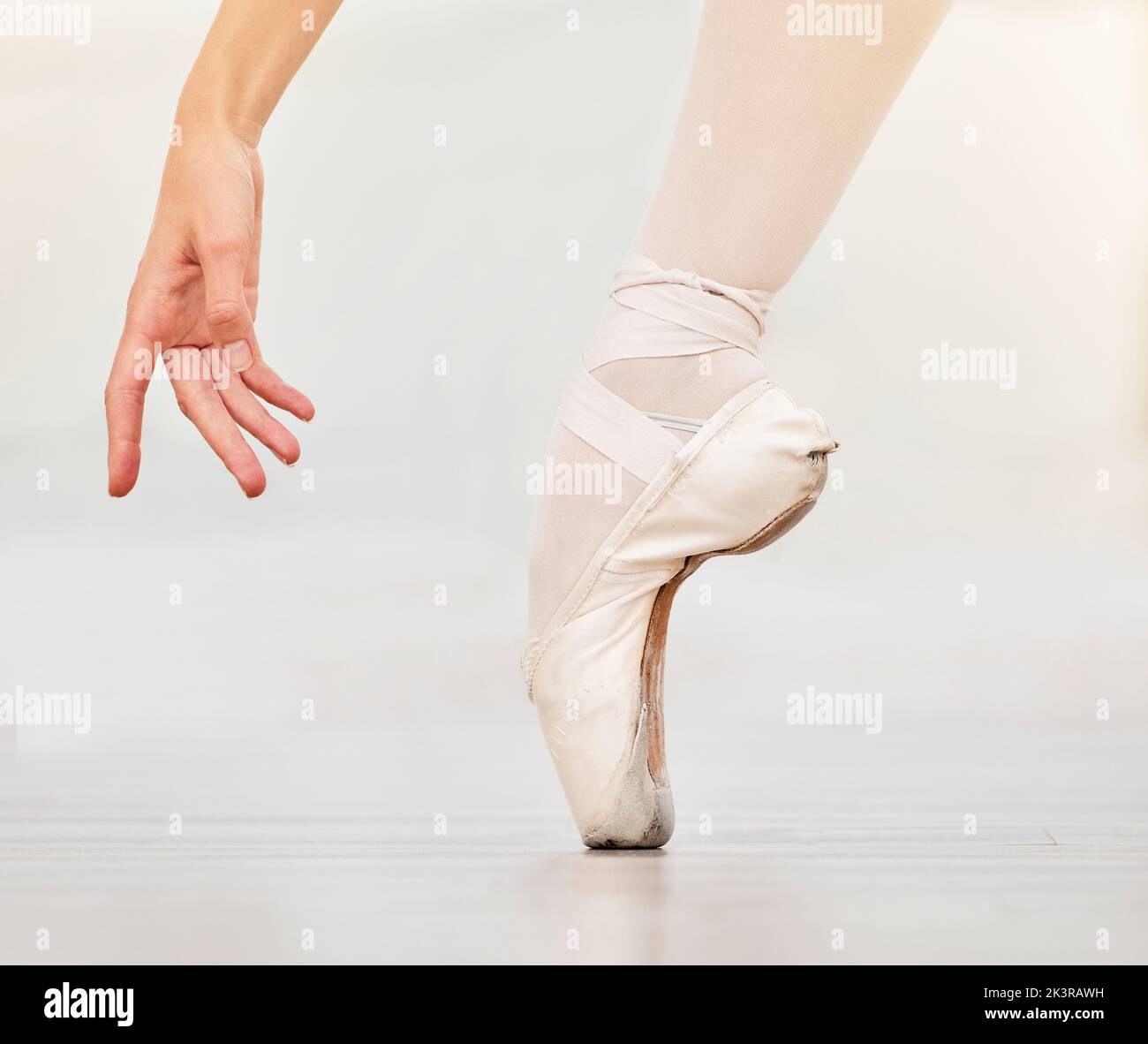 Nahaufnahme des Fußes des Tänzers auf dem Boden, des Ballettschuhs und der Hand, zeigen Haltung und Gleichgewicht beim Tanzunterricht. Zoom der Frau tanzen im Studio zu üben oder auf der Bühne Stockfoto