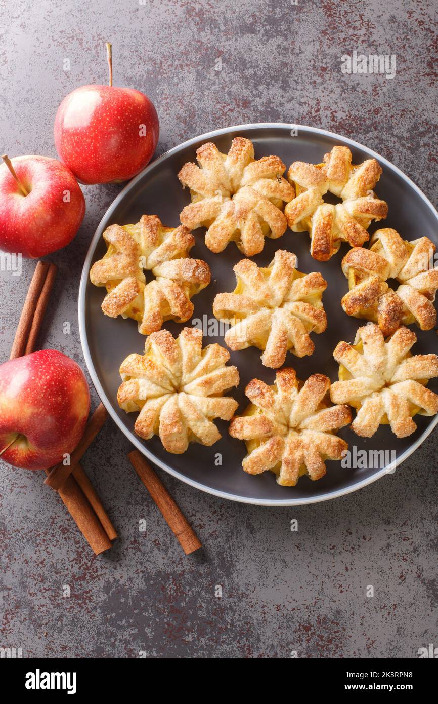 Herbstliche Äpfel, die in Teig gebacken wurden, aus der Nähe auf einem Teller auf dem Tisch. Vertikale Draufsicht von oben Stockfoto