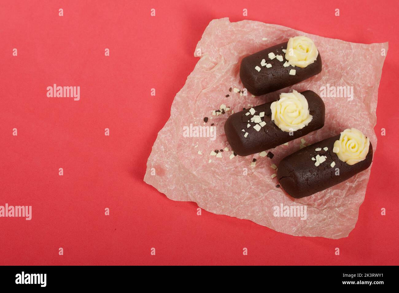 Tortenkartoffel. Dekoriert mit Buttercreme. Auf einem rosa Hintergrund. Nahaufnahme. Stockfoto