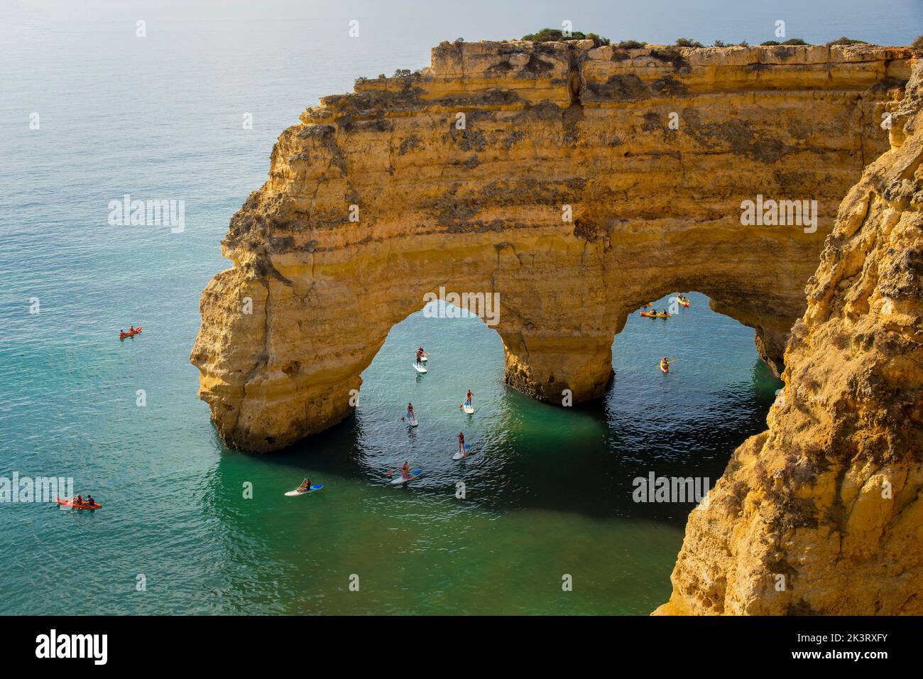 Lagoa, Portugal, September 2022: Kajaks und Surfbretter, die unter dem Arco Natural an der Küste der Algarve in Portugal paddeln. Stockfoto