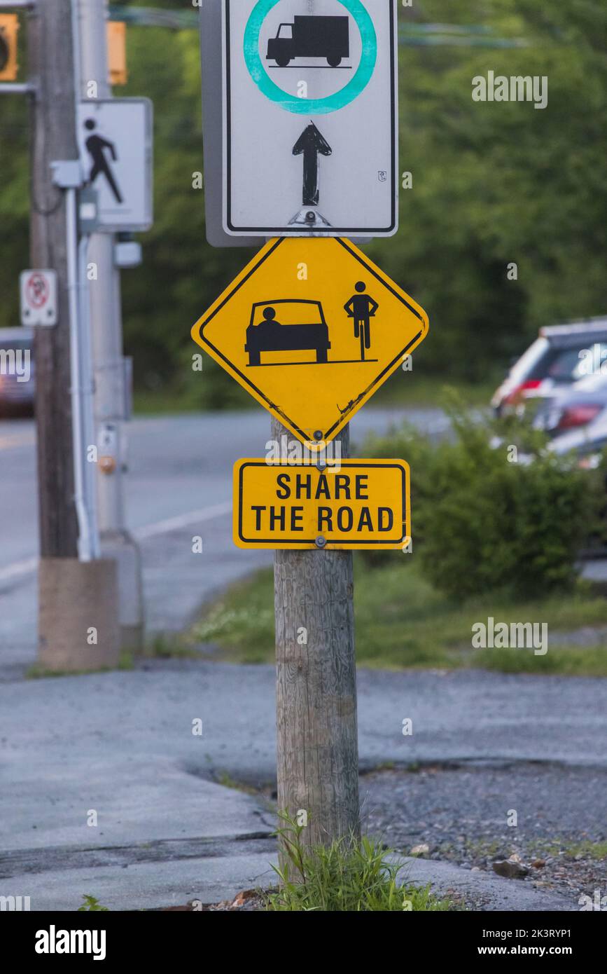 TEILEN SIE DIE STRASSE ein Straßenschild mit einem Fahrrad-Symbol zur Information für den Verkehr. Warnschild Mit Gelbem Diamanten Stockfoto