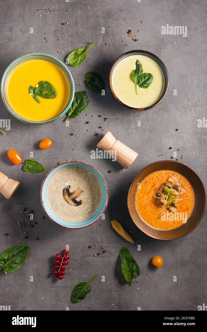 Vier verschiedene leckere Suppen mit Kräutern dekoriert. Draufsicht Stockfoto