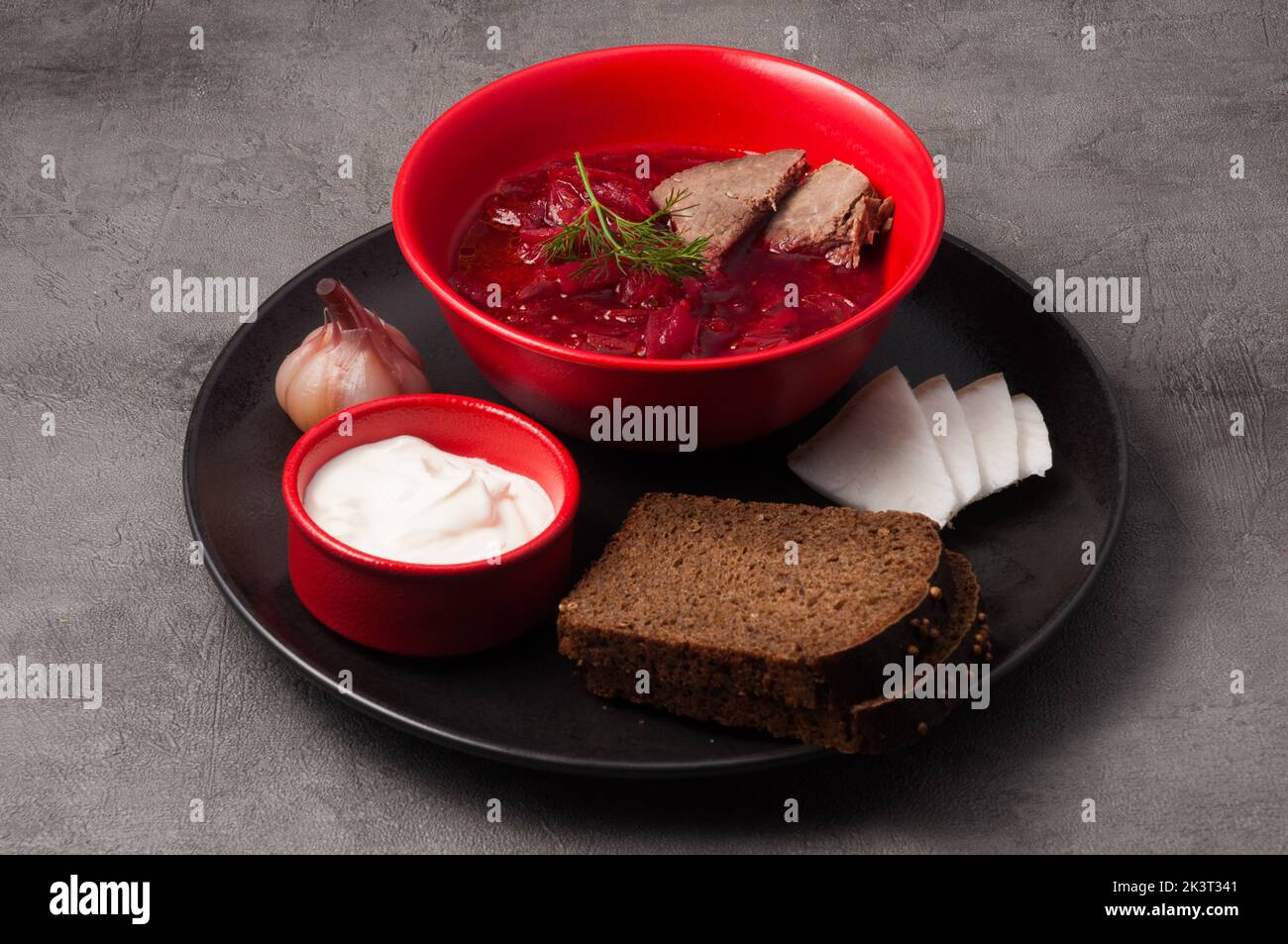 Leckeres russisches und ukrainisches Suppenborscht mit Schwarzbrot, Speck und Sauerrahm Stockfoto