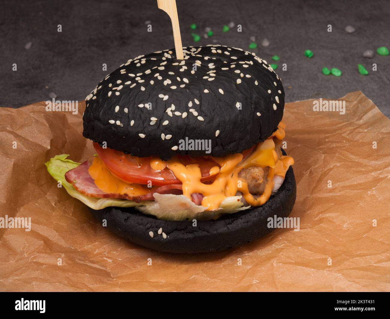 Leckerer schwarzer Burger mit Specktomate, panierter Hähnchen- und Käsesauce Stockfoto