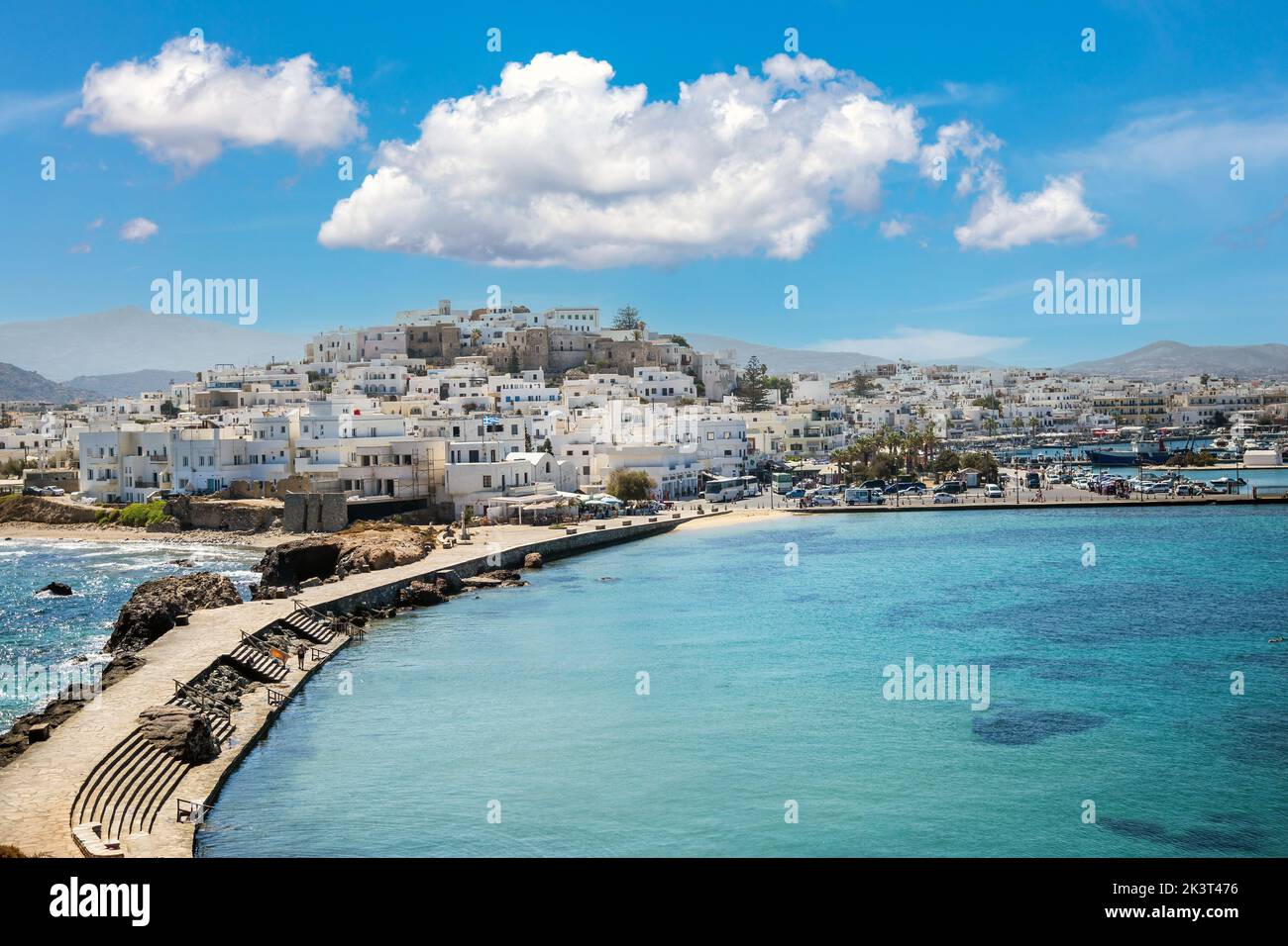 Griechenland, Erreichen Naxos Hafen, Kykladen Inseln. Blick vom Schiff auf die traditionellen weiß getünchten Häuser auf dem Hügel. Ruhiges Meer, blauer Himmel. Sommerziel. Stockfoto