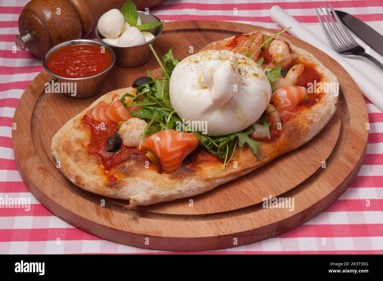 Leckere klassische italienische Pizza mit Buratta-Käse und Lachs Stockfoto