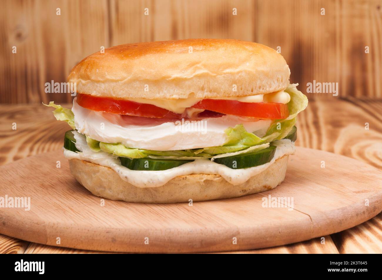 Schmackhafter vegetarischer Burger mit Frischkäse, Gurke und Tomaten Stockfoto