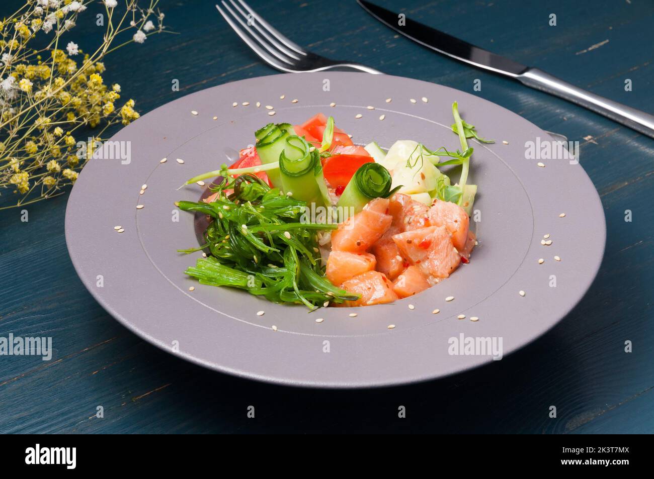 Schmackhafter Poke mit Lachs und Gemüse, verziert mit Sesam Stockfoto