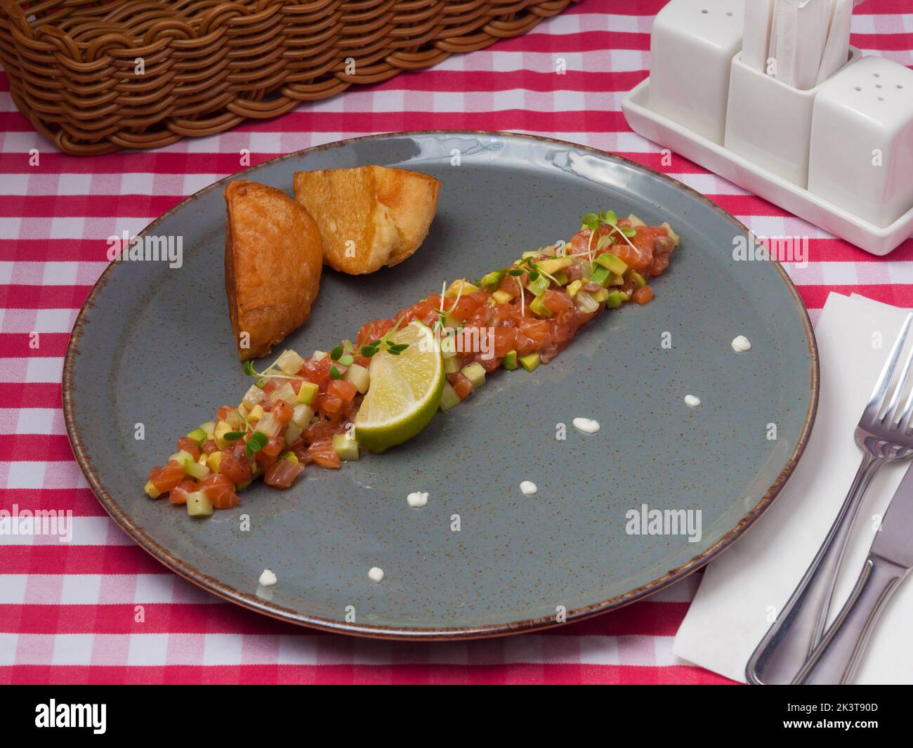 Leckere Lachstartare mit Avocado und einer Scheibe Limette im Restaurant Stockfoto