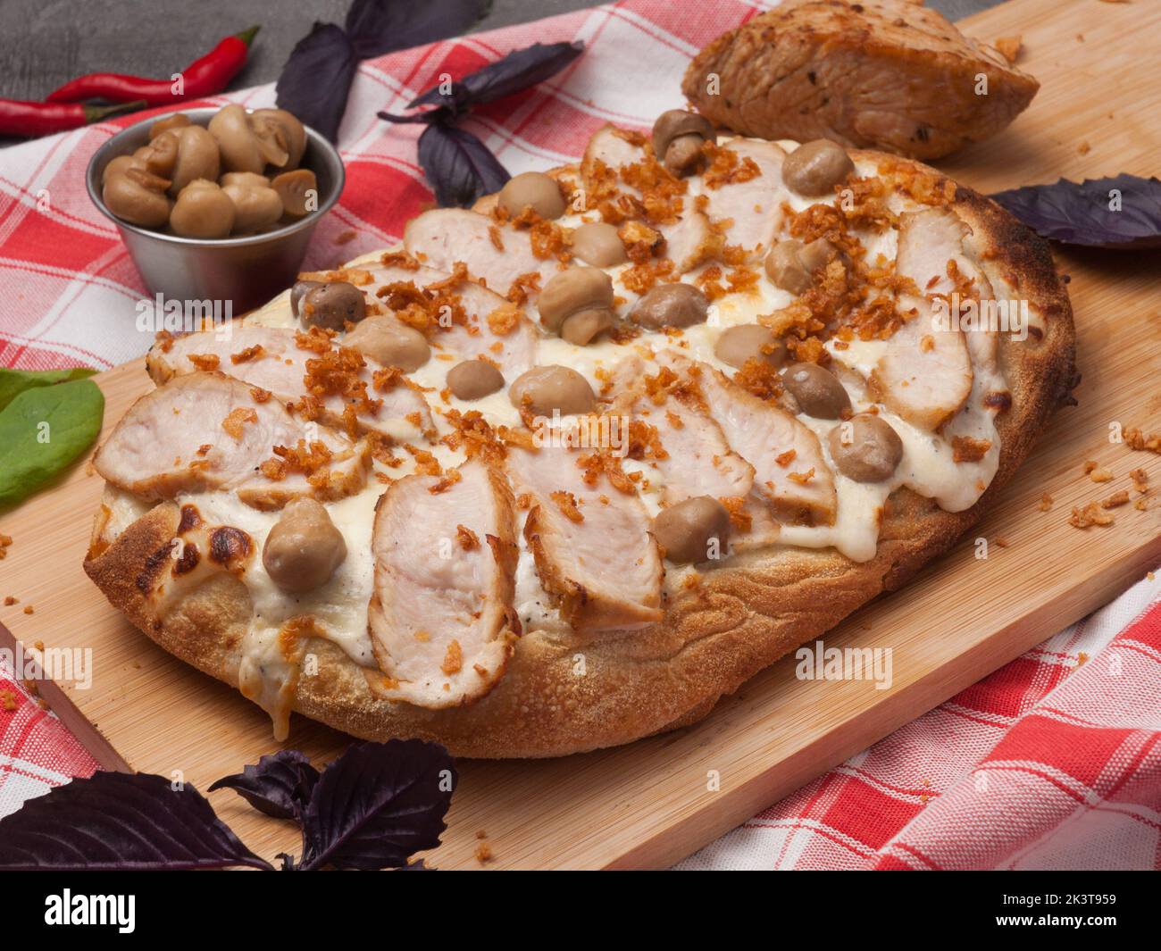 Leckere Pizza mit truthahn und Pilzen auf einem Holzbrett Stockfoto