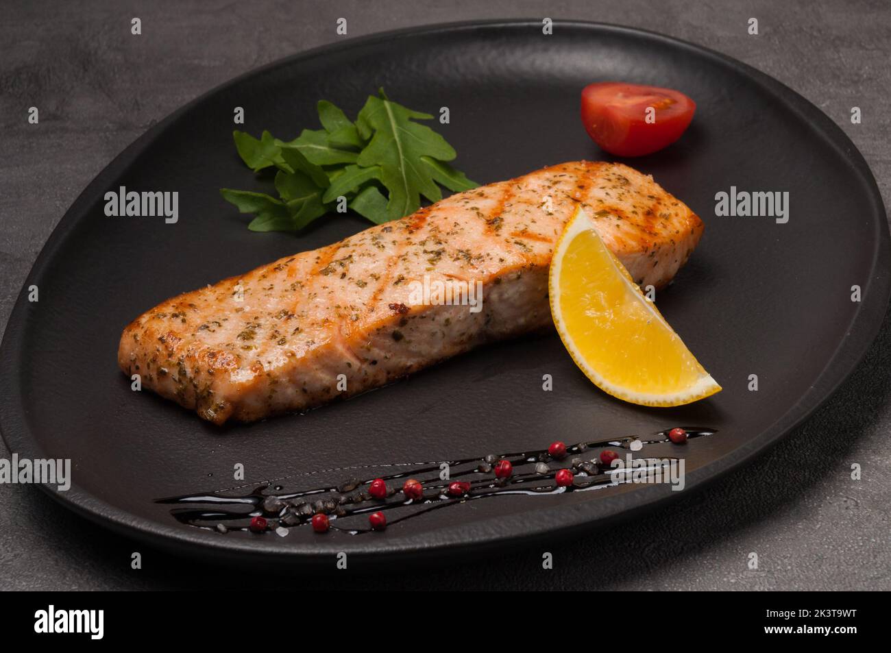 Leckeres gegrilltes Lachssteak auf einem dunklen Teller Stockfoto