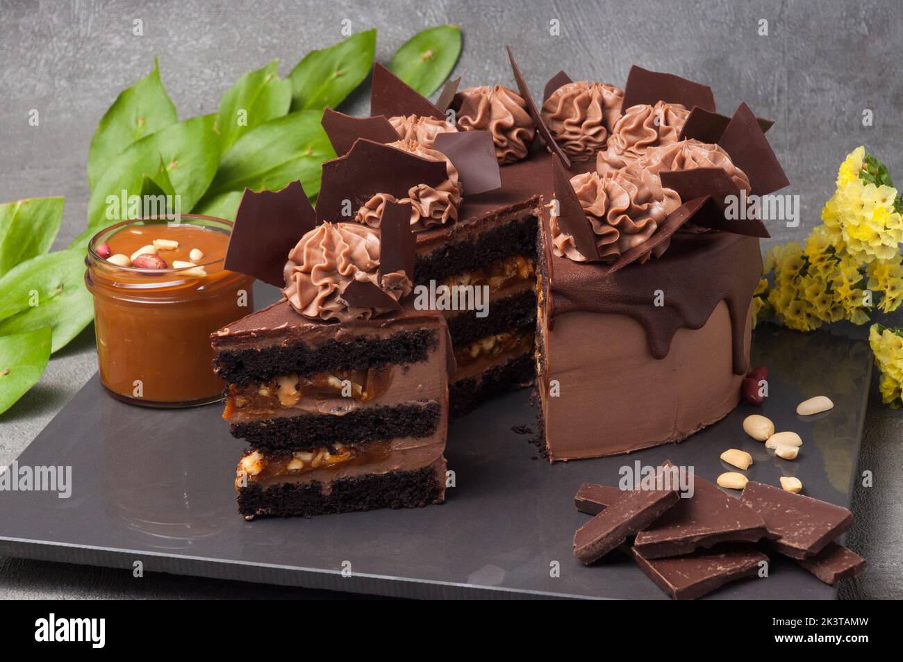 Süßer Schokoladen-Biskuit, eingeweicht in dunklen Schokoladencremekäse und Erdnusspaste, mit Karamell und gerösteter Erdnussfüllung Stockfoto