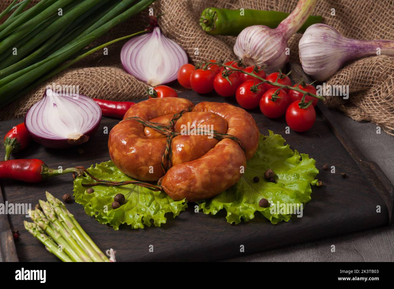 Leckere Wurst aus einem Holzofen, dekoriert mit frischem Gemüse Stockfoto