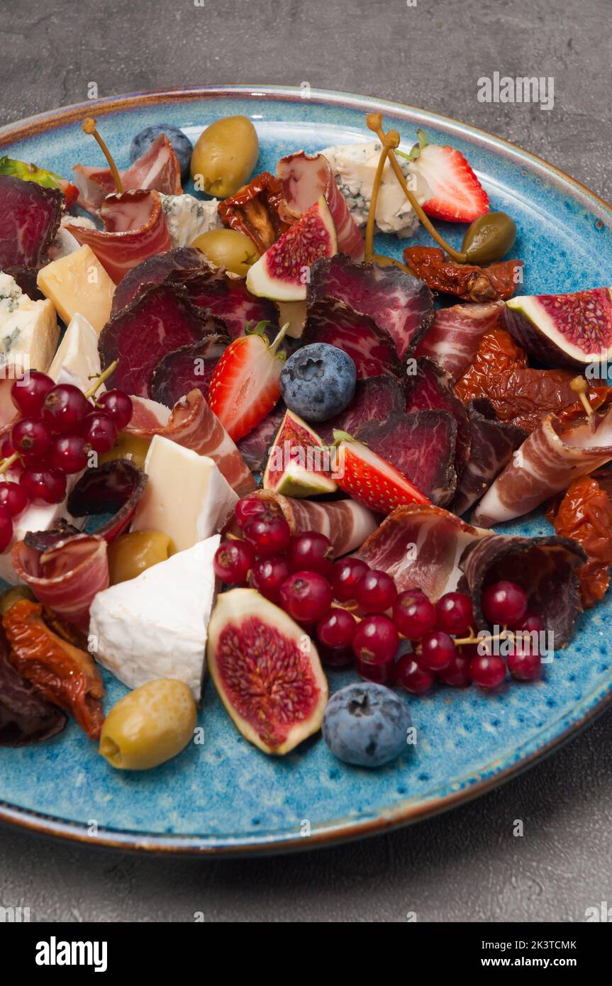 Antipasto - leckere kalte Vorspeise mit getrocknetem Fleisch, Obst, Käse, Beeren Stockfoto