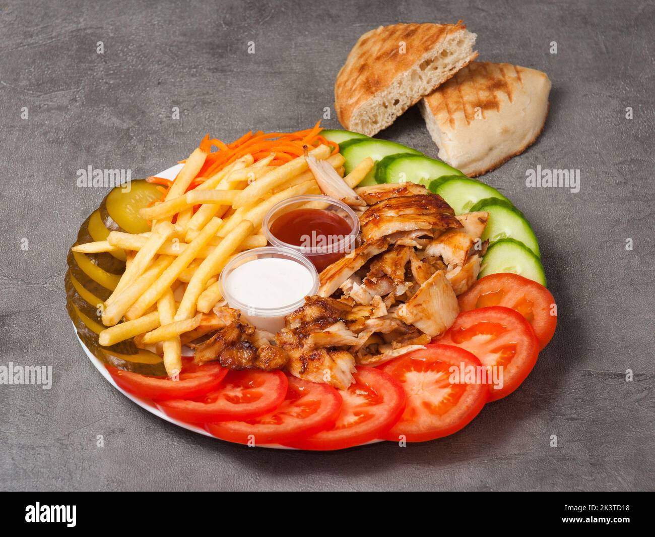 Leckere Shawarma auf einem Teller mit pommes Frites und Sauce auf grauem Hintergrund Stockfoto