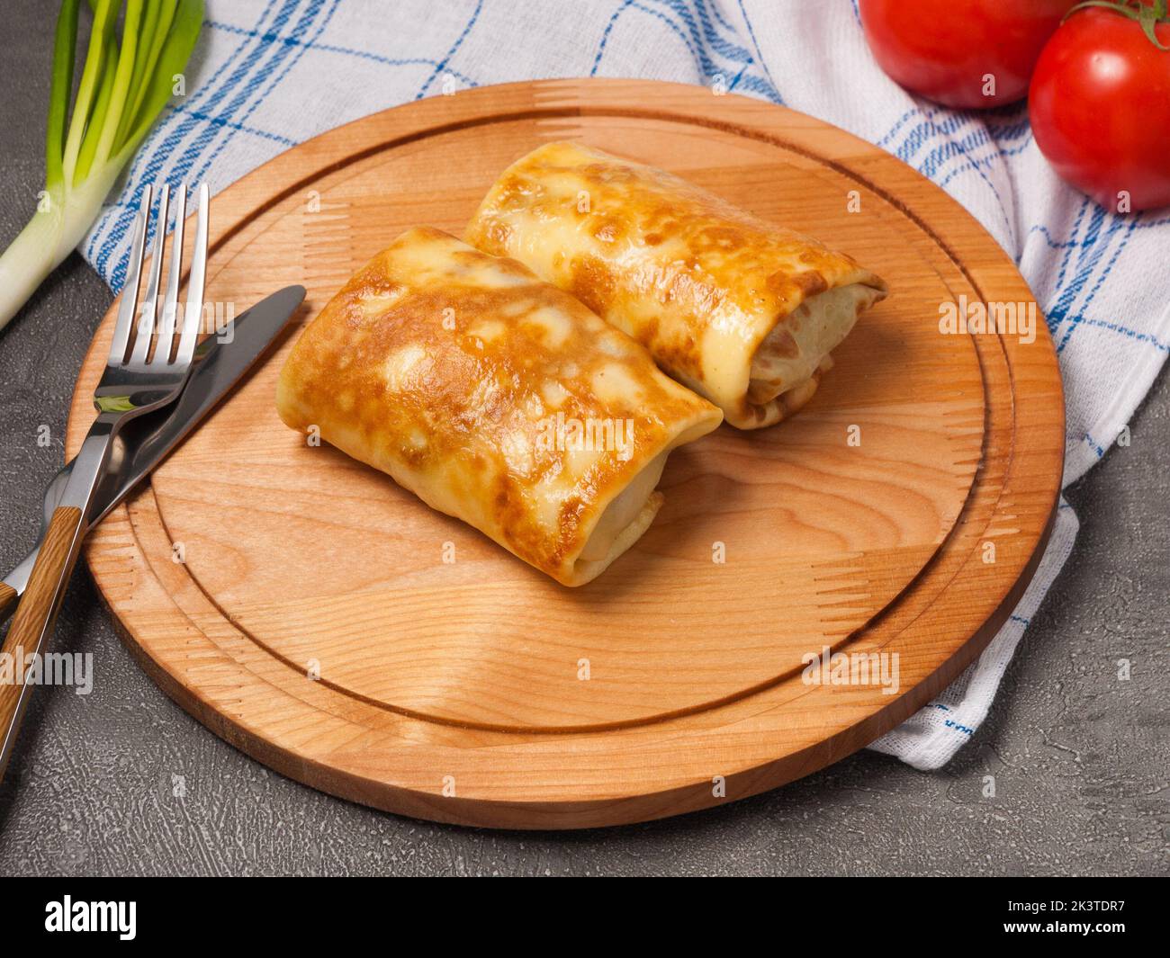 Leckere Pfannkuchen mit Füllung auf einem Holzbrett Stockfoto