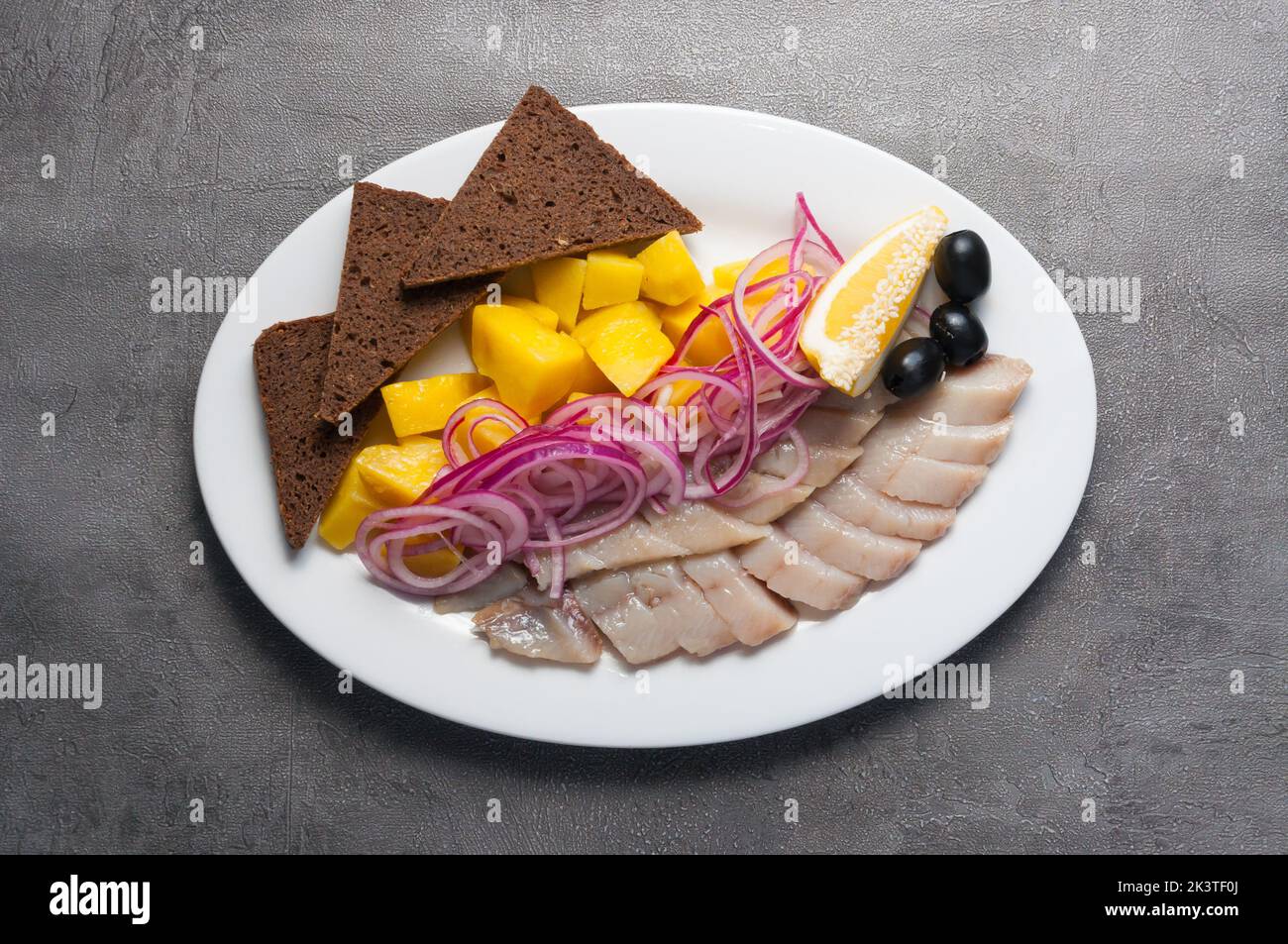 Leckere kalte Vorspeise - gesalzener Hering mit Kartoffeln und roten Zwiebeln Stockfoto