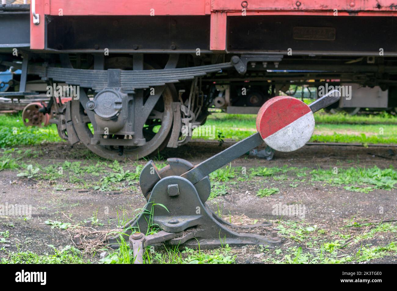 Foto eines alten Gleisschalthebels. Waggonrad im Hintergrund. Stockfoto
