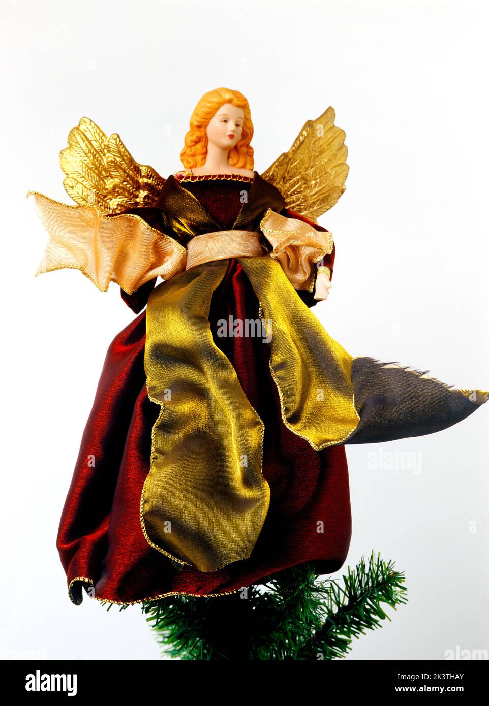 Fee trägt rotes Samtkleid mit goldenen Flügeln auf dem Weihnachtsbaum Stockfoto
