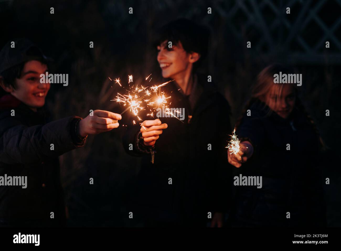 Gruppe junger Jugendlicher, die mit Funkeln auf dem Wald spielen Stockfoto