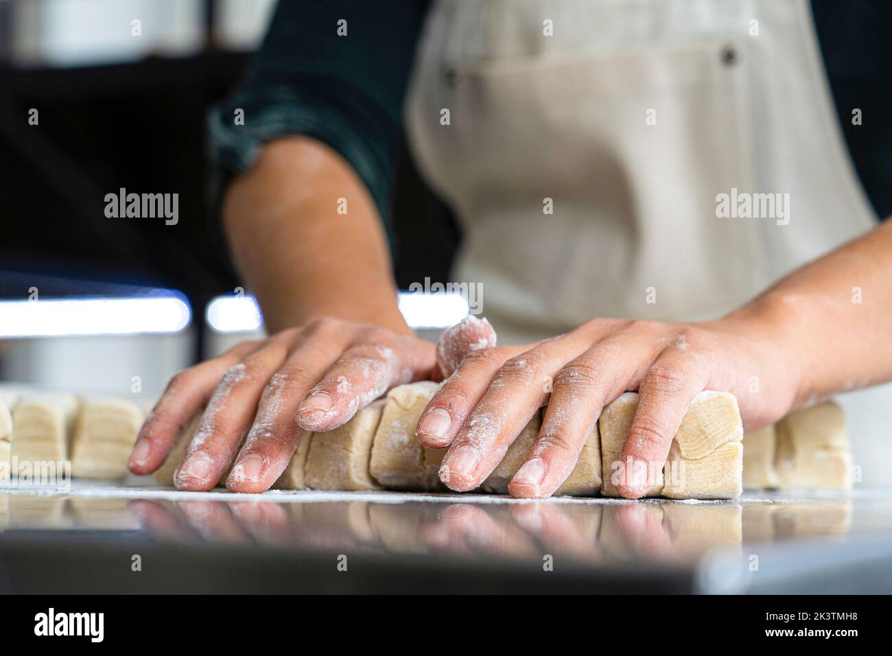 Flache Ansicht der Hände der Bäckerin beim Kneten von Gebäck Stockfoto