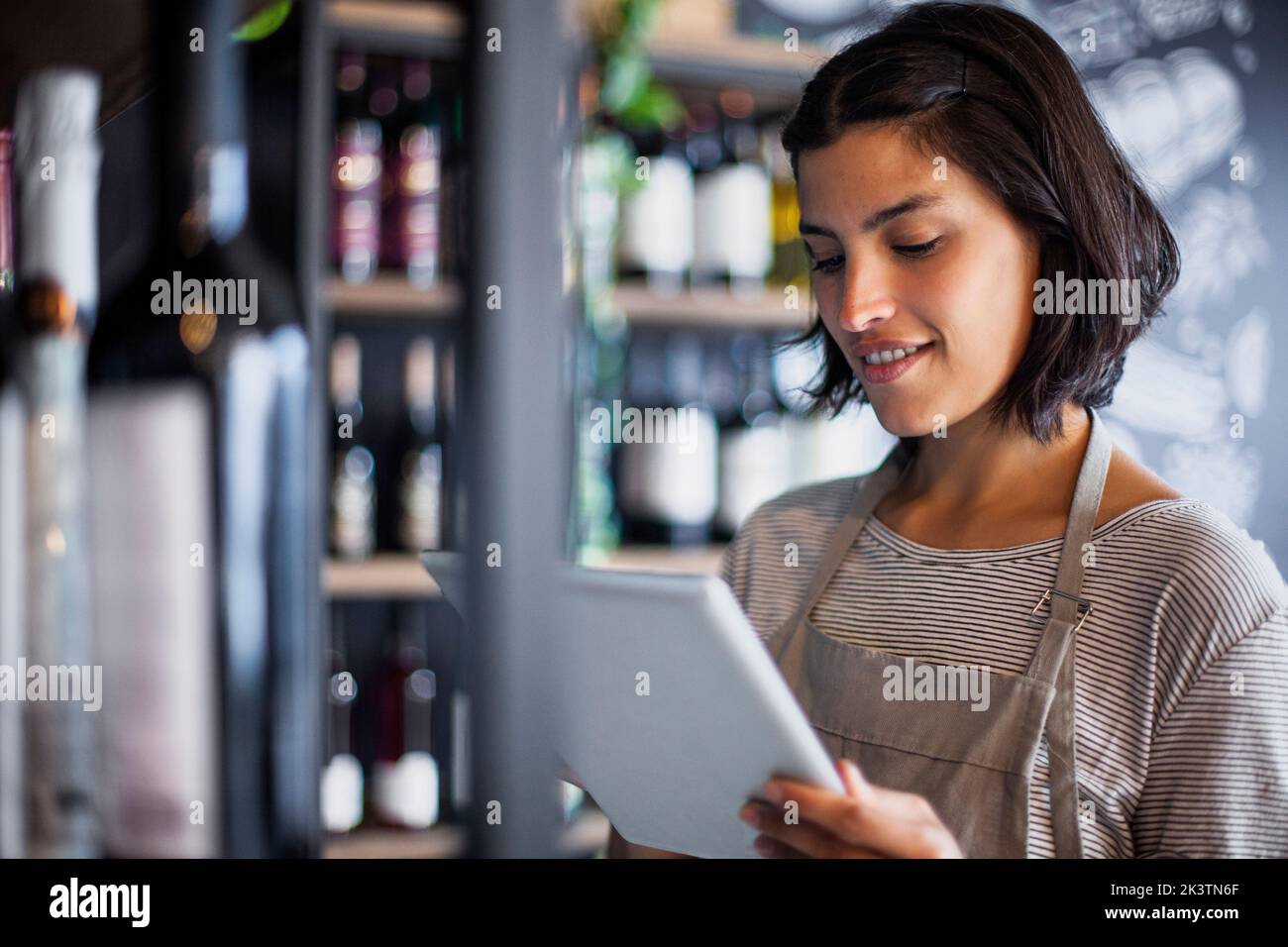 Mitarbeiter des Weinhauses nimmt die Flascheninventarisierung auf einem digitalen Tablet auf Stockfoto