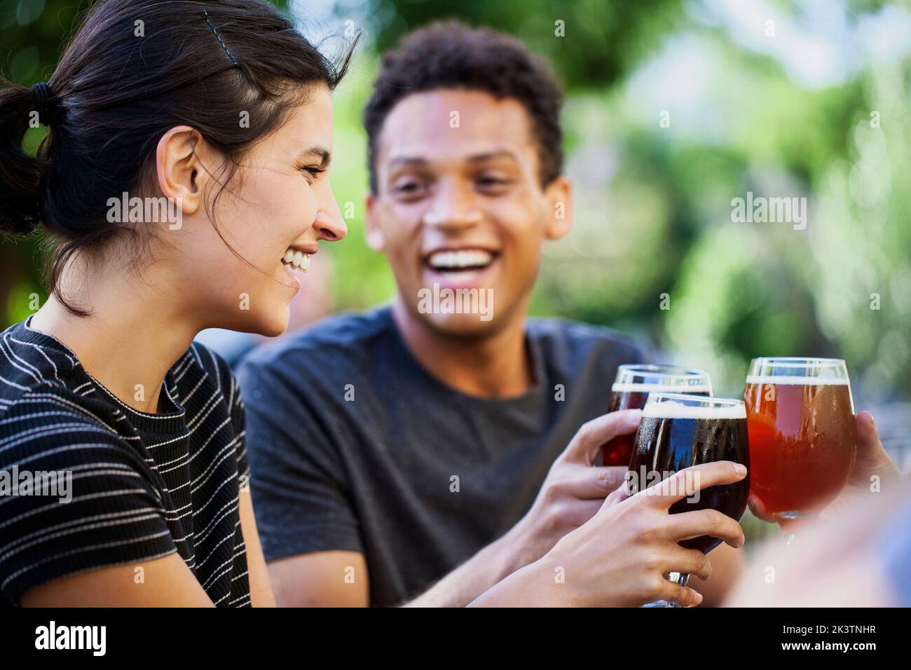 Junge Erwachsene Frau und Freunde toasten mit Bier Stockfoto