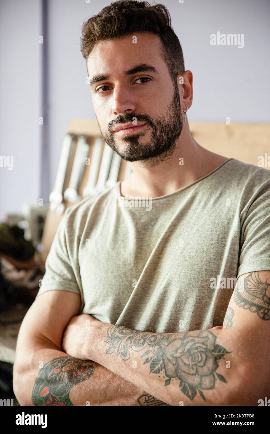 Junger erwachsener männlicher Mechaniker, der in der Werkstatt steht Stockfoto