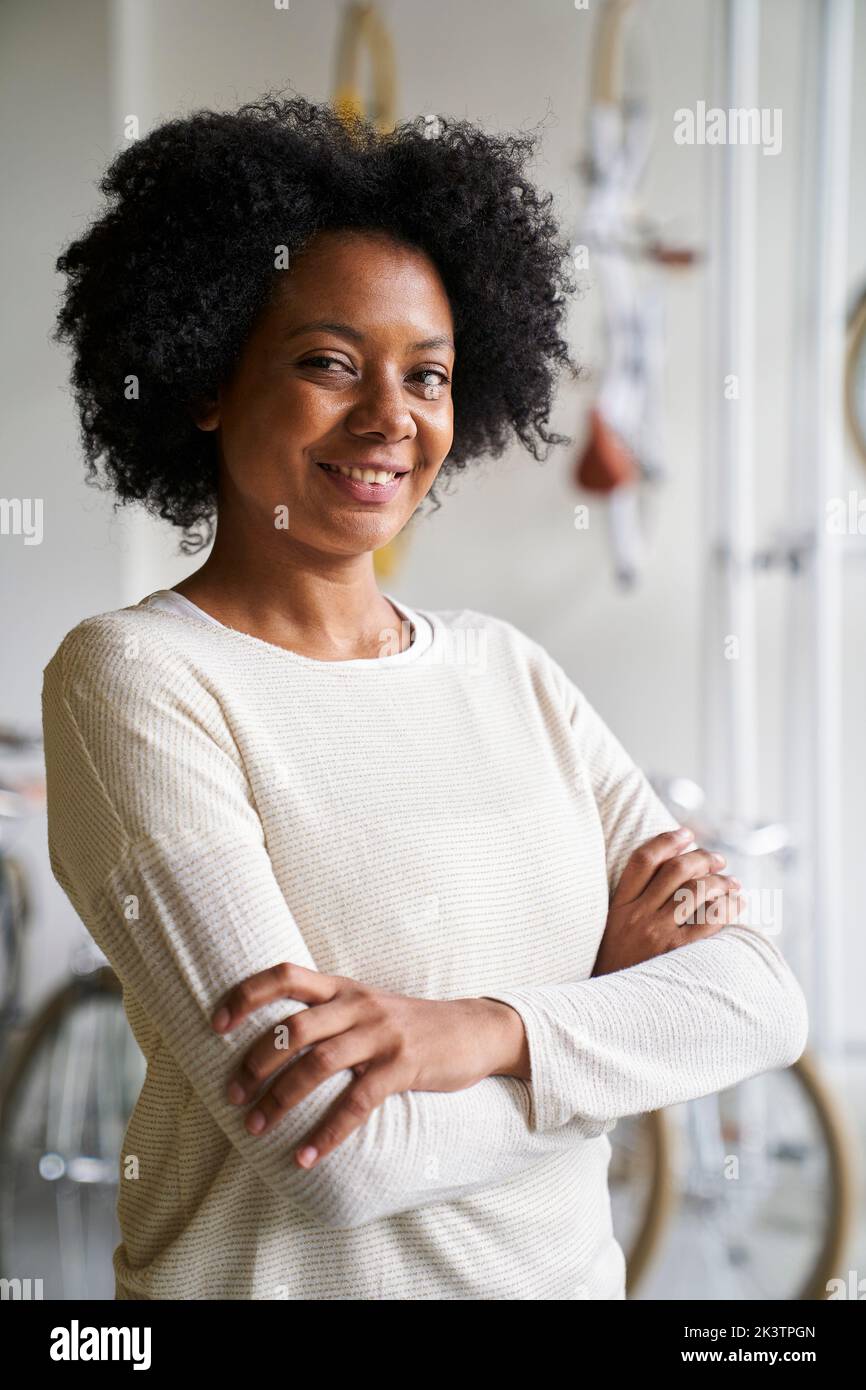 Mittellange Aufnahme einer afroamerikanischen Unternehmerin, die in ihrem Geschäft auf die Kamera schaut Stockfoto