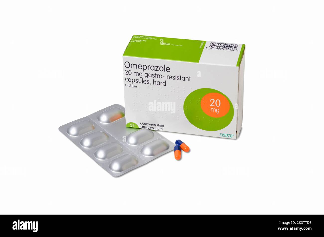 Foto der Packung mit 20mg Omeprazol Kapseln Box Blister-Packung und zwei Kapseln Pillen auf weißem Hintergrund ausgeschnitten Stockfoto