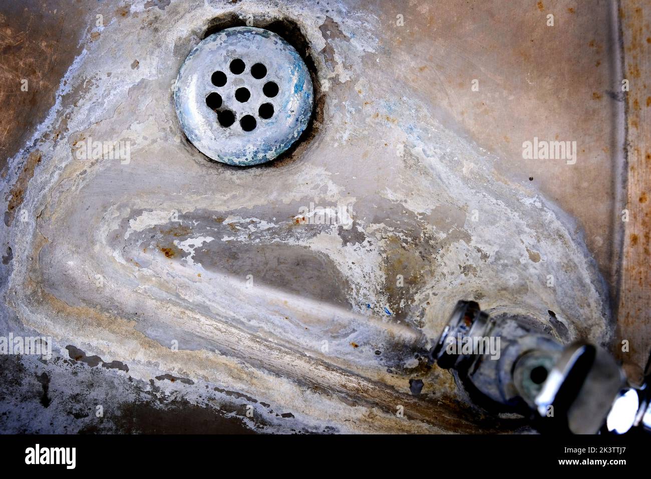 Alt verwittert und verfleckt Abfluss in Waschbecken harten Wasser Textur Stockfoto