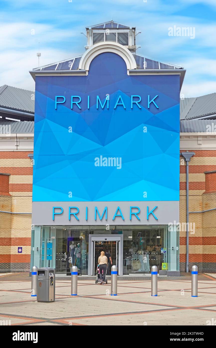 Kunden, die in das Primark Retail Clothing Business Store außerhalb der Sicherheitsbohlen im Lakeside Shopping Center Malls West Thurrock Essex England, Großbritannien, einreisen Stockfoto
