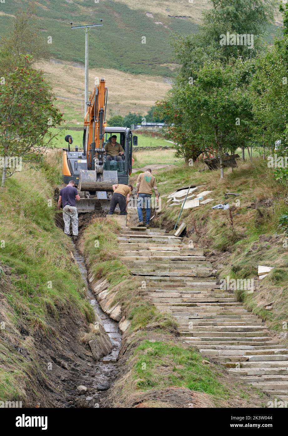 Verlegung von Pflasterplatten und Verbesserung der angrenzenden Entwässerung auf dem Fußweg zum Pendle Hill, um Schäden zu beheben, die durch Wanderstiefel verursacht wurden Stockfoto