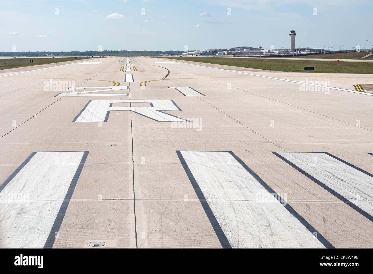 Start- und Landebahn 21R am Detroit Metropolitan Wayne County Airport (DTW) in Detroit, Michigan, USA, mit Kontrollturm und Terminals im Hintergrund. Stockfoto