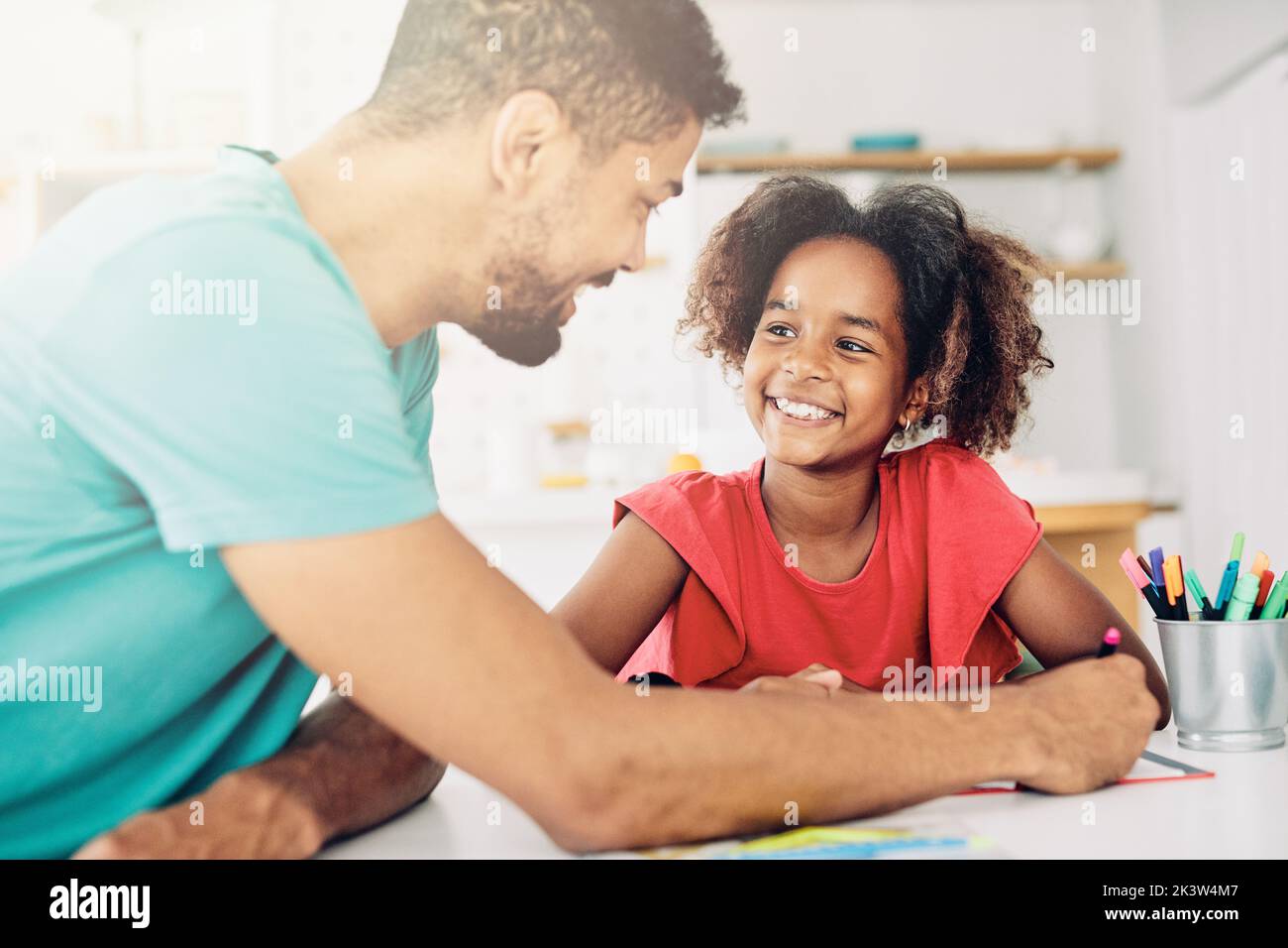 Vater unterrichtet Tochter und hilft bei Hausaufgaben zu Hause Stockfoto