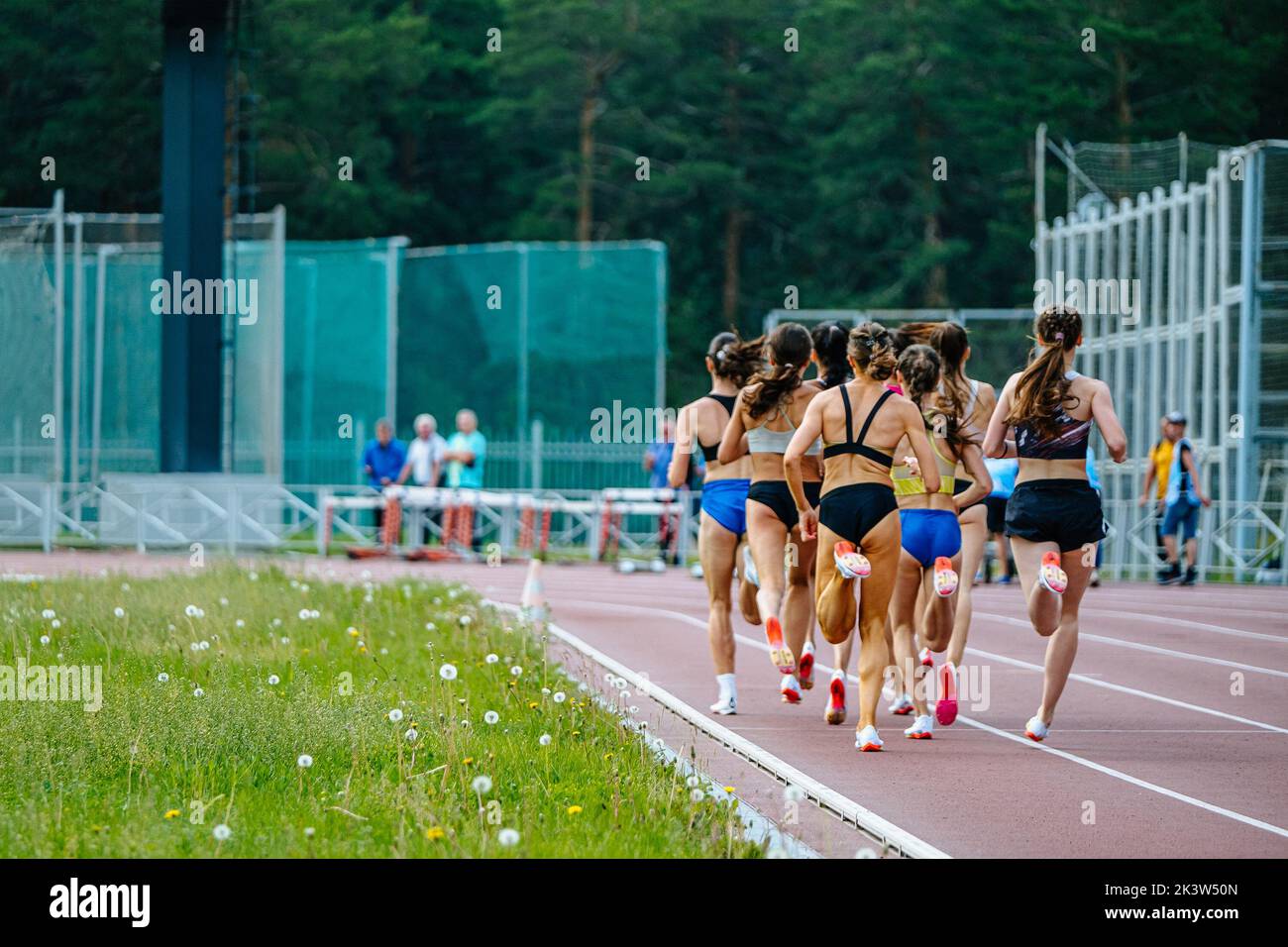Weibliche Gruppenathleten laufen auf der mittleren Distanz Stockfoto