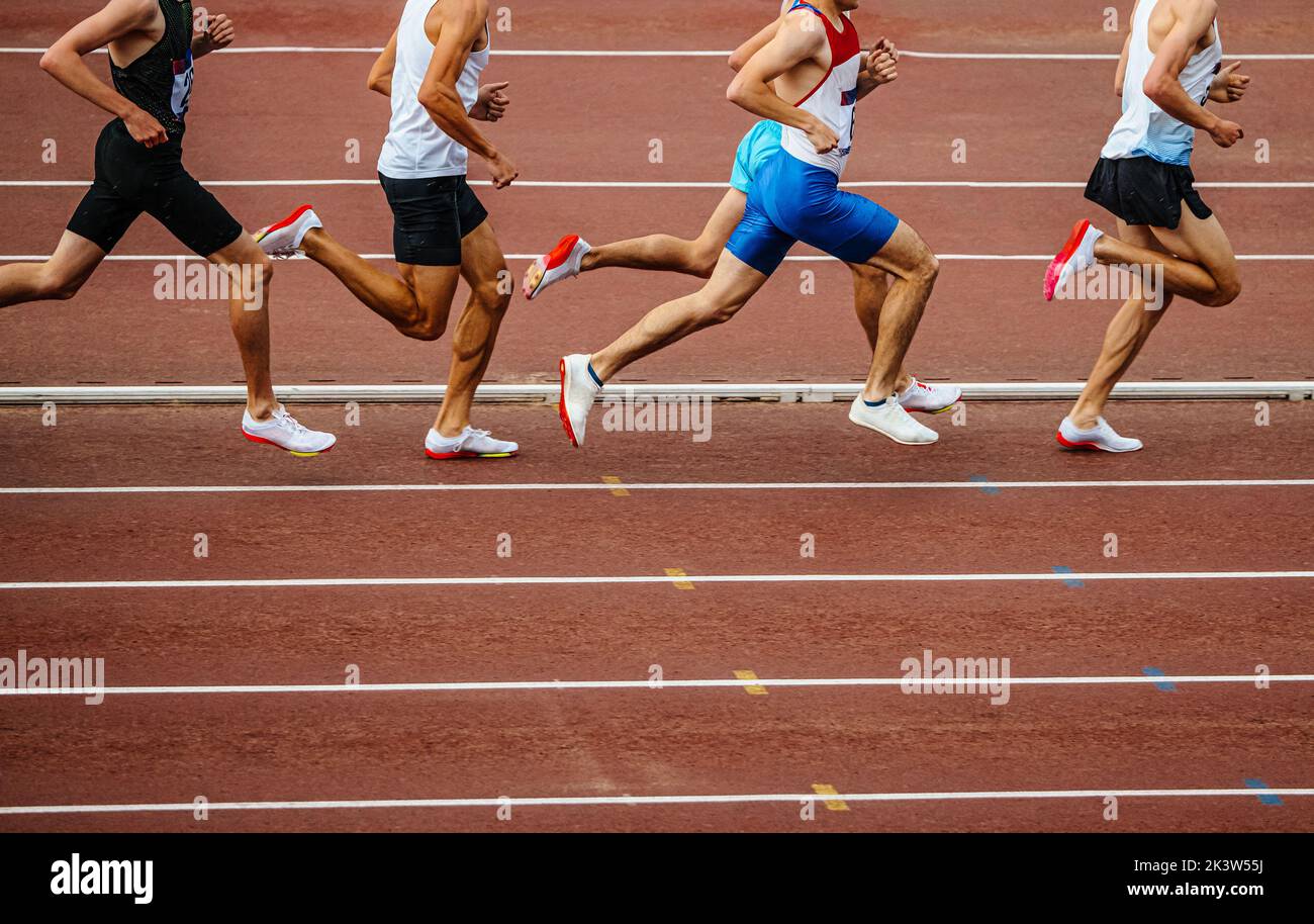 Die männlichen Gruppenathleten führen ein Mittelstreckenrennen durch Stockfoto