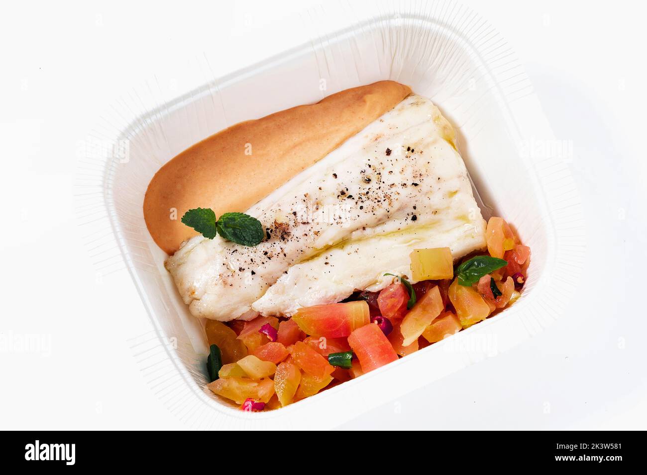 Seebarsch Filet mit Tomatensalat und Sauce in einem Plastikbehälter zum Mitnehmen Stockfoto