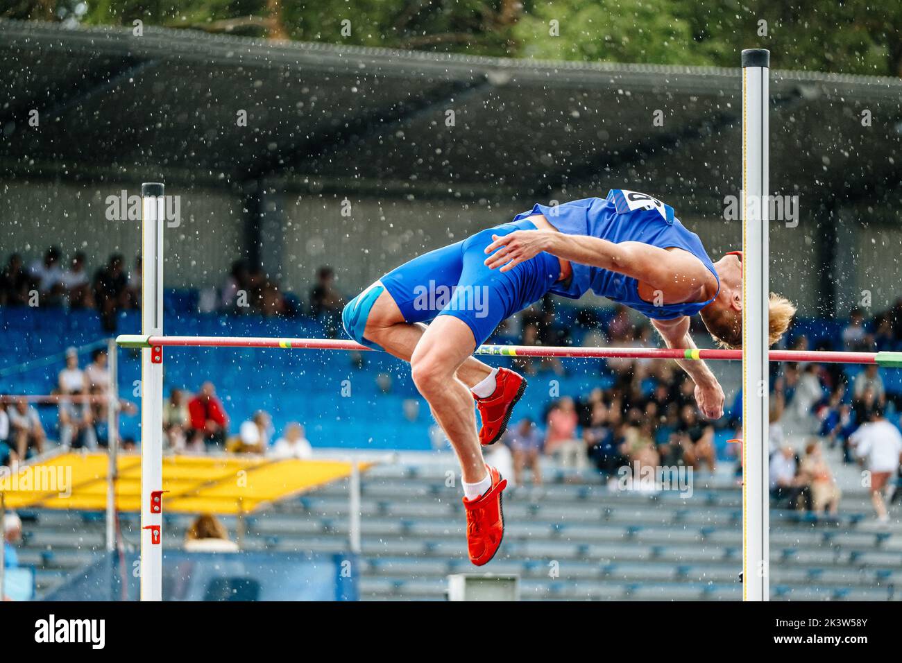Erfolgloser Versuch Athlet Hochsprung im Regen Stockfoto