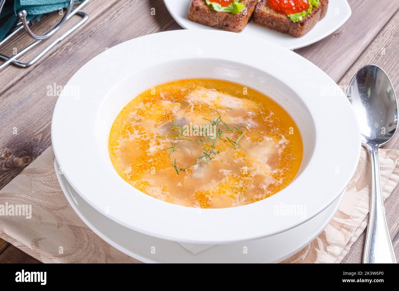 Fischsuppe: Russische Fischsuppe mit Sandwiches und rotem Kaviar auf einem Teller auf dunklem Holzboden Stockfoto