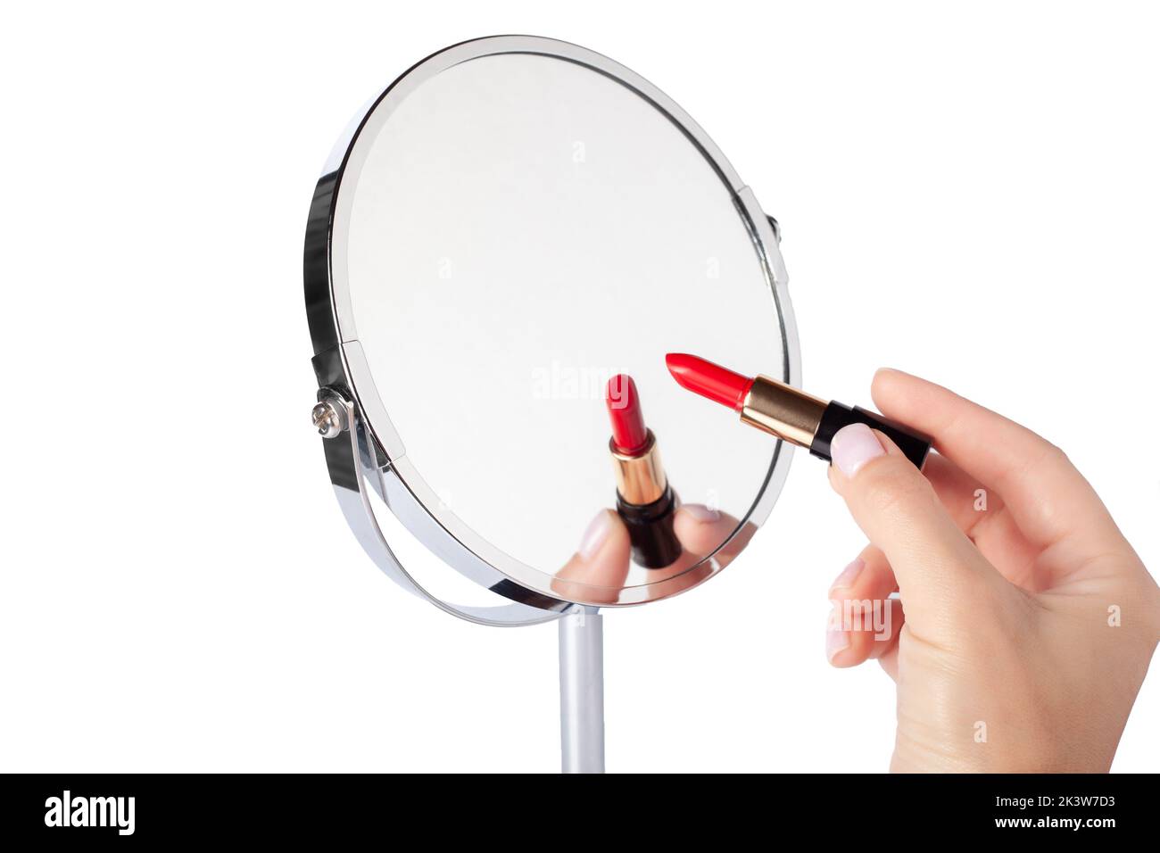 Weibliche Hand mit roter Lippenstift Zeichnung auf Spiegel. Desktop Make-up Kosmetikspiegel isoliert. Home Metallspiegel Nahaufnahme isoliert. Gesichtsspiegel Stockfoto