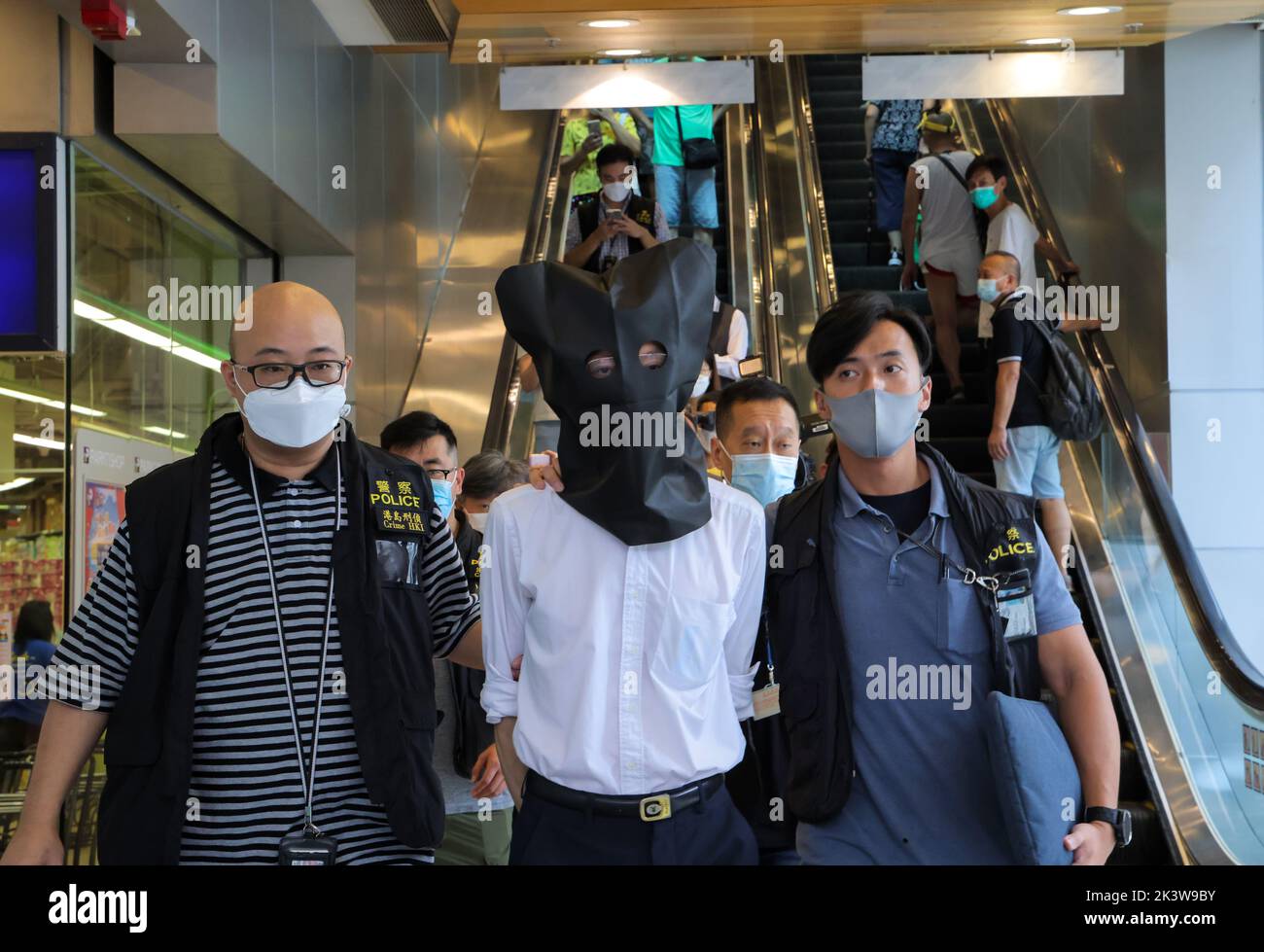 Polizisten eskortieren einen Verdächtigen aus der Klinik von Doktor Wong Ping-leung in hing Wah Plaza, Chai Wan. Dr. Wong von Chai Wan, Dr. Charlie Yan kam-Sun von Yuen Long und Dr. Amy Lam Ding-yee von Tin Shui Wai wurden verhaftet, weil sie illegal Covid-19-Impfgenehmigungen ausgestellt hatten. 22SEP22 Jelly Tse/SCMP Stockfoto