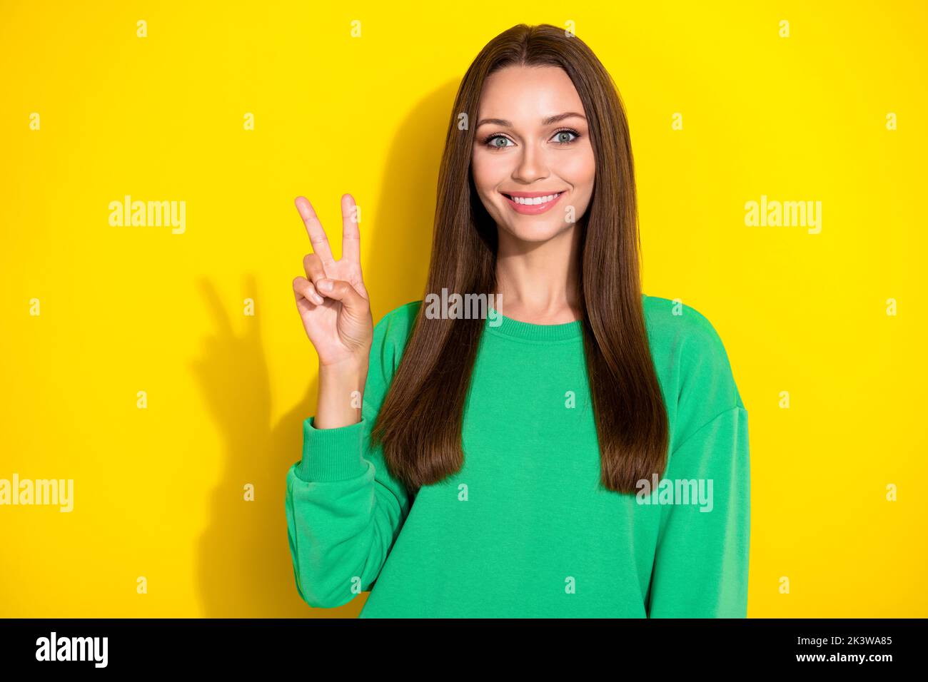Portrait Foto von jungen wunderschönen Dame zeigt V-Zeichen lächelnd toothy glücklich isoliert auf gelbem Hintergrund Stockfoto