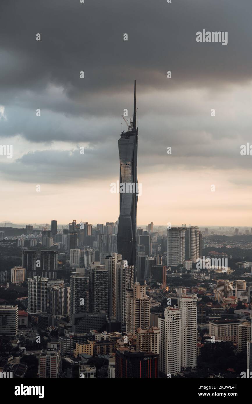 Eine vertikale Aufnahme der wunderschönen städtischen Skyline von Kuala Lumpur bei Sonnenuntergang mit dem Warisan Merdeka Tower Stockfoto