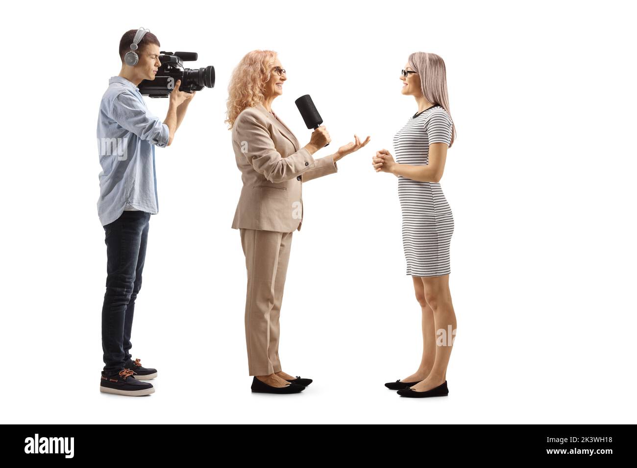 Weibliche Reporterin interviewte eine junge Frau und einen Kameramann, der isoliert auf weißem Hintergrund Aufnahmen Stockfoto