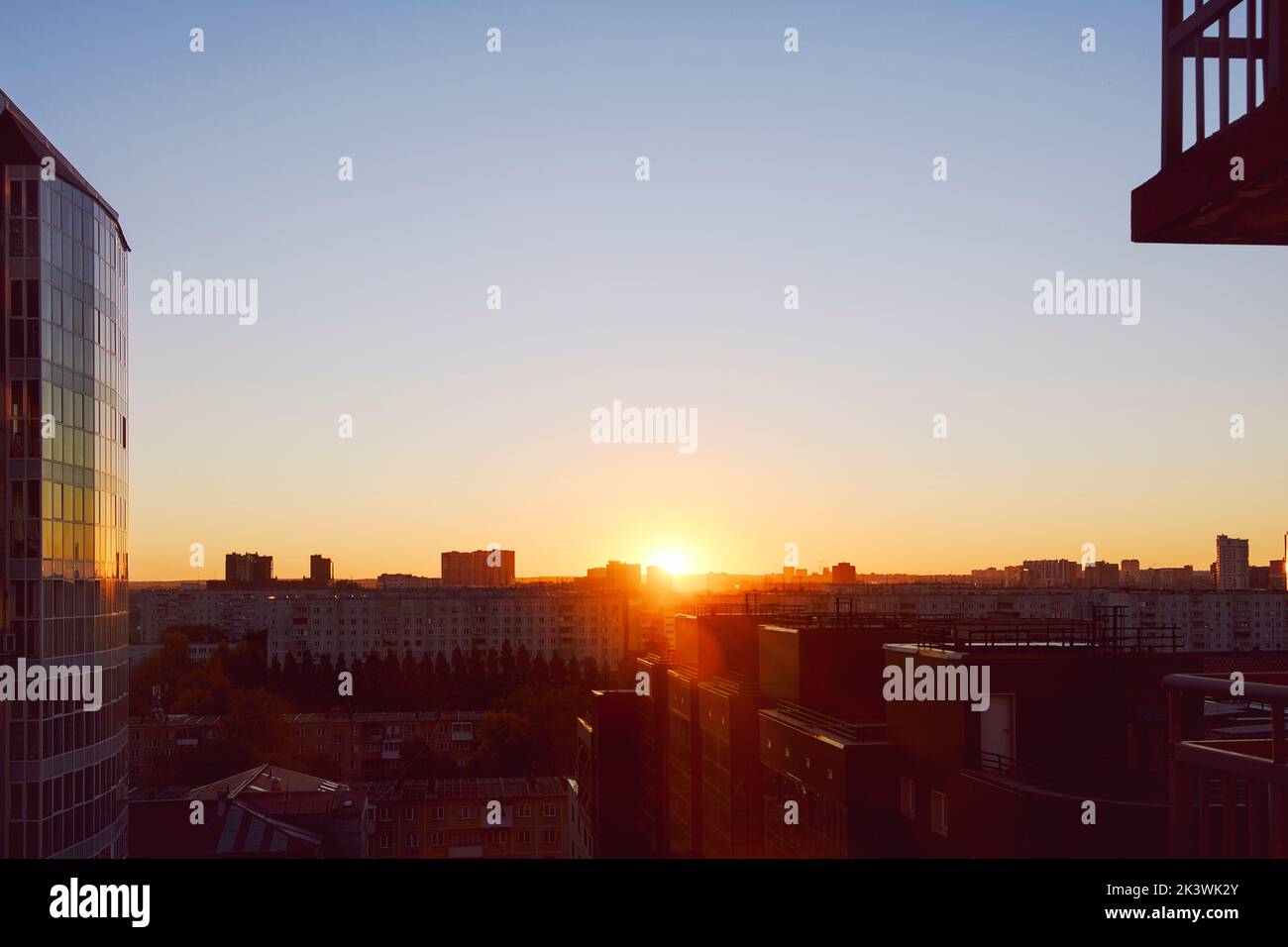 Die Sonne geht über der Skyline auf und erhellt die Häuser und Straßen der schlafenden Stadt Stockfoto
