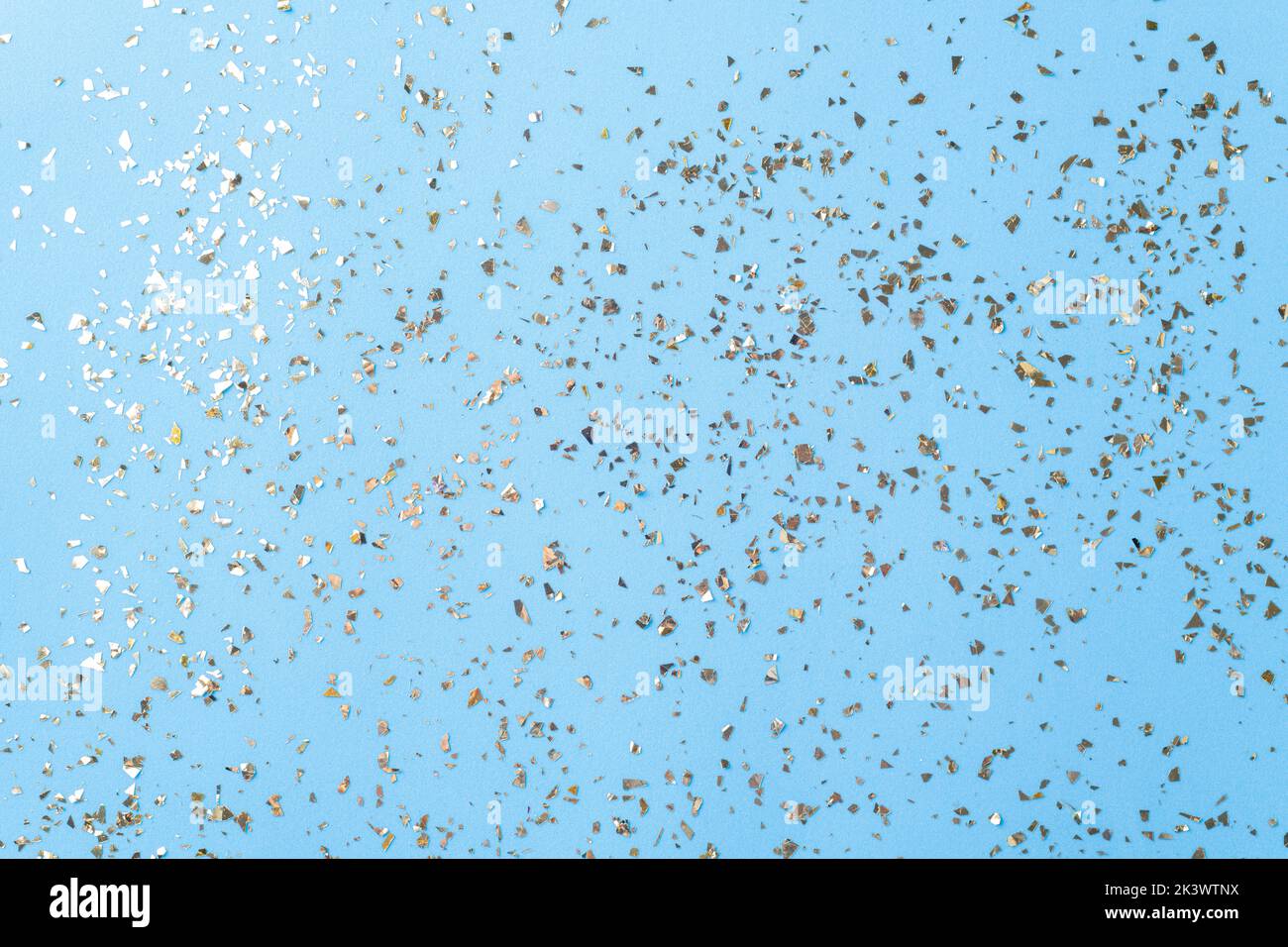 Goldenes Fliegen funkelt auf blauem Art und Weiseurlaub Hintergrund. Festlicher Hintergrund. Textur aus goldenem Glitzer auf Blau Stockfoto